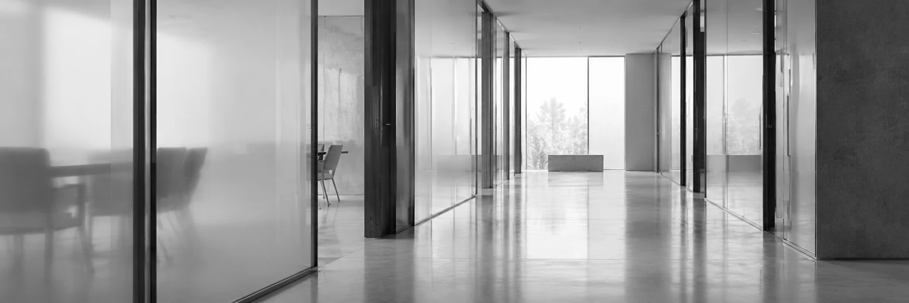 A quiet, light-filled architectural corridor with open doorways